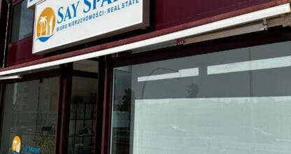 Fachada de la oficina de Say Spain! Real Estate con rótulo y escaparates en La Manga del Mar Menor