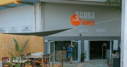 Centro de buceo Scuba Murcia con terraza de madera, sombrilla y rótulo naranja con servicios dive, buceo y snorkel