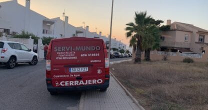 Furgoneta roja de SERVI-MUNDO Cerrajero con rótulos de electricista y fontanero en zona residencial de La Manga