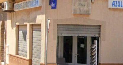 Fachada exterior en esquina del local Simón Sáez con rótulos de materiales de construcción y azulejos, La Manga del Mar Menor