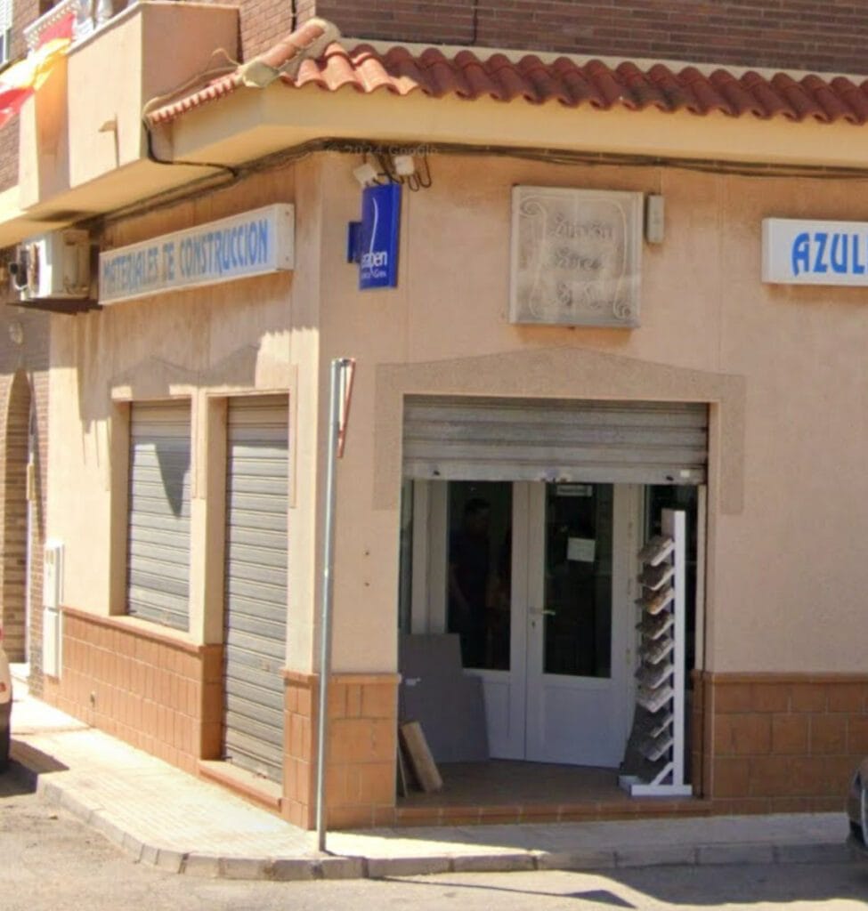 Fachada exterior en esquina del local Simón Sáez con rótulos de materiales de construcción y azulejos, La Manga del Mar Menor