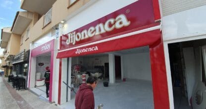 Fachada de la heladería smöoy en La Manga del Mar Menor durante obras de acondicionamiento, junto a la tienda Jijonenca en la misma calle peatonal