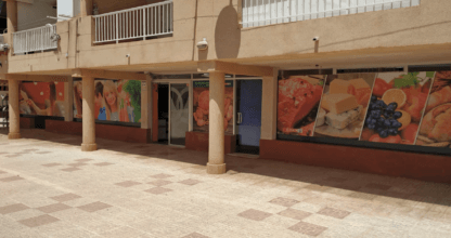 Fachada del Spar Express Puerto Bello en La Manga del Mar Menor con escaparates decorados con murales de frutas y productos frescos
