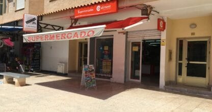 Fachada exterior del Supermercado Coaliment en La Manga del Mar Menor con toldo rojo y cartel de supermercado