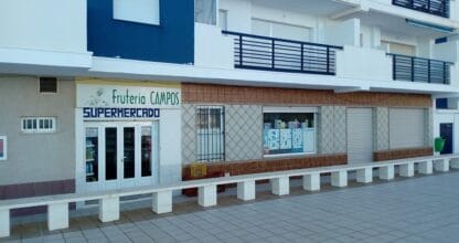 Fachada exterior de Supermercado Fruteria Campos en La Manga del Mar Menor, local de planta baja con rótulo verde y azul en edificio blanco