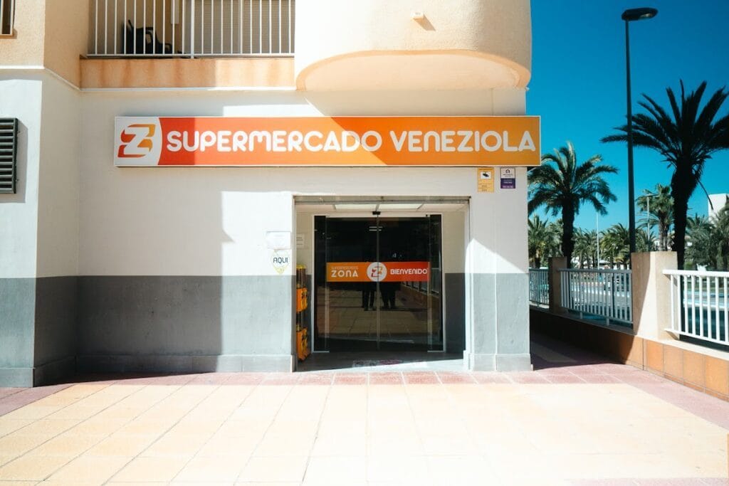 Entrada del Supermercado Veneziola con rótulo naranja y palmeras en La Manga del Mar Menor