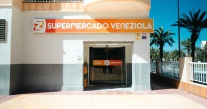 Entrada del Supermercado Veneziola con rótulo naranja y palmeras en La Manga del Mar Menor