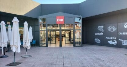 Entrada del supermercado Dia en La Manga del Mar Menor con puertas automáticas de cristal y murales de carnicería y pescadería en fachada gris