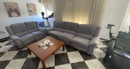Sala de espera con sofás grises en L y mesa de centro del Taller de costura MBA en La Manga del Mar Menor