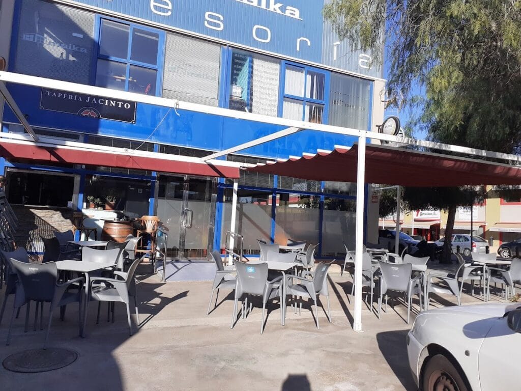 Terraza exterior con mesas y sillas de Tapería Jacinto bajo toldo, bar de tapas en La Manga del Mar Menor