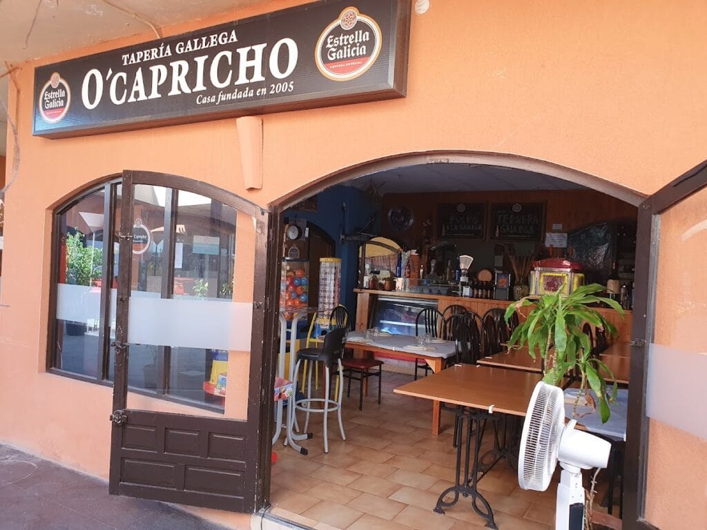 Fachada de Tapería Gallega O'Capricho en La Manga del Mar Menor, local con toldo y rótulo 'Casa fundada en 2005', mesas y barra al fondo