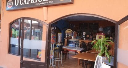 Fachada de Tapería Gallega O'Capricho en La Manga del Mar Menor, local con toldo y rótulo 'Casa fundada en 2005', mesas y barra al fondo