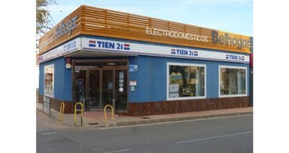 Fachada azul de la tienda de electrodomésticos Tien21 Belhogar con rótulo en esquina, La Manga del Mar Menor