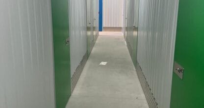Pasillo interior con trasteros de puertas verdes en Trasteros Cabo de Palos La Manga, Murcia