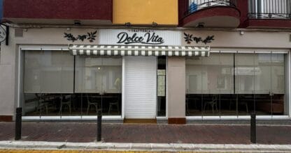 Fachada exterior de Trattoria Dolce Vita en La Manga del Mar Menor con toldo a rayas verdes y rótulo con decoración de olivo