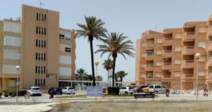 Zona residencial Urbanización Maracaibo en La Manga con palmeras, aparcamiento y dos bloques de apartamentos al fondo