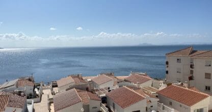 Vista panorámica de tejados blancos con tejas rojas de Urbanización Pedrucho Mar frente al Mar Mediterráneo en día soleado