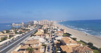 Vista aérea de la urbanización Ágata III con villas, avenida y playa del Mar Mediterráneo en La Manga del Mar Menor