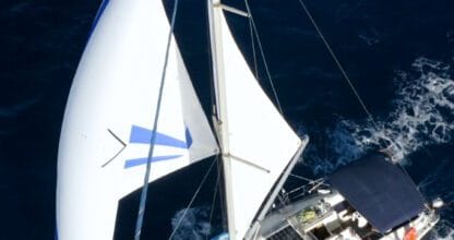 Velero con spinnaker azul y blanco navegando en aguas abiertas, charter veleroantidoto La Manga del Mar Menor
