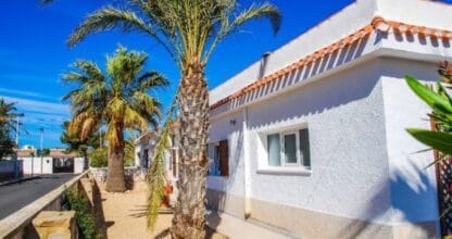 Villa blanca de alquiler vacacional con palmeras en el jardín y cielo azul, alojamiento Villa Fortuna en La Manga del Mar Menor