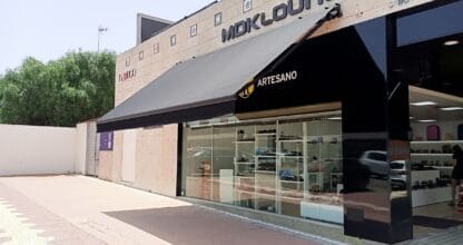 Fachada exterior de Zapaterías Salvador Artesano con amplio escaparate de calzado y toldo negro en Cabo de Palos